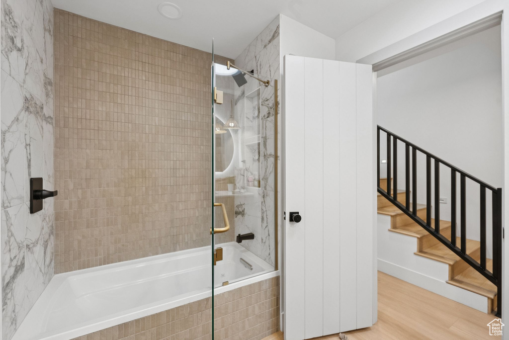 Bathroom featuring tiled shower / bath and wood finished floors