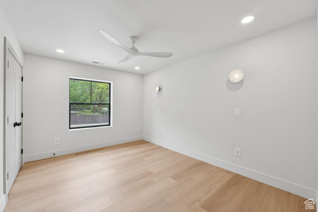 Empty room featuring light wood-style floors, ceiling fan, and recessed lighting