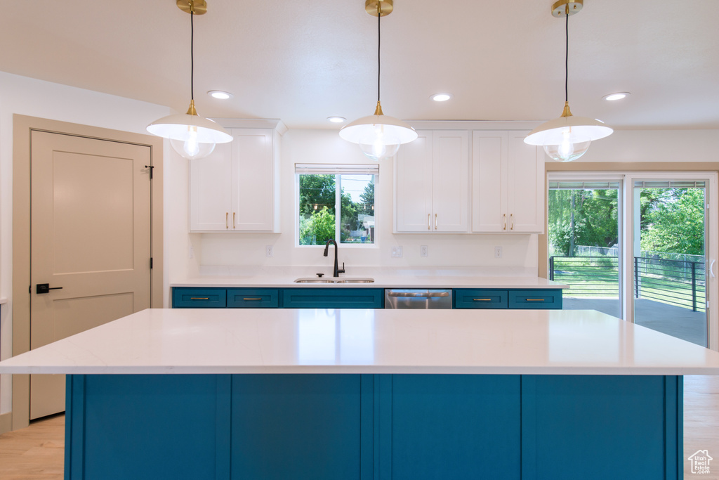 Kitchen featuring a sink, blue cabinets, dishwasher, light countertops, and recessed lighting