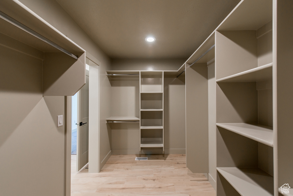 Walk in closet with light wood-style flooring