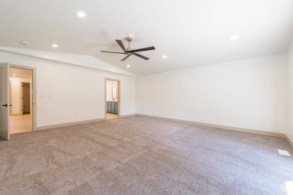 Empty room with a ceiling fan, light carpet, recessed lighting, lofted ceiling, and baseboards
