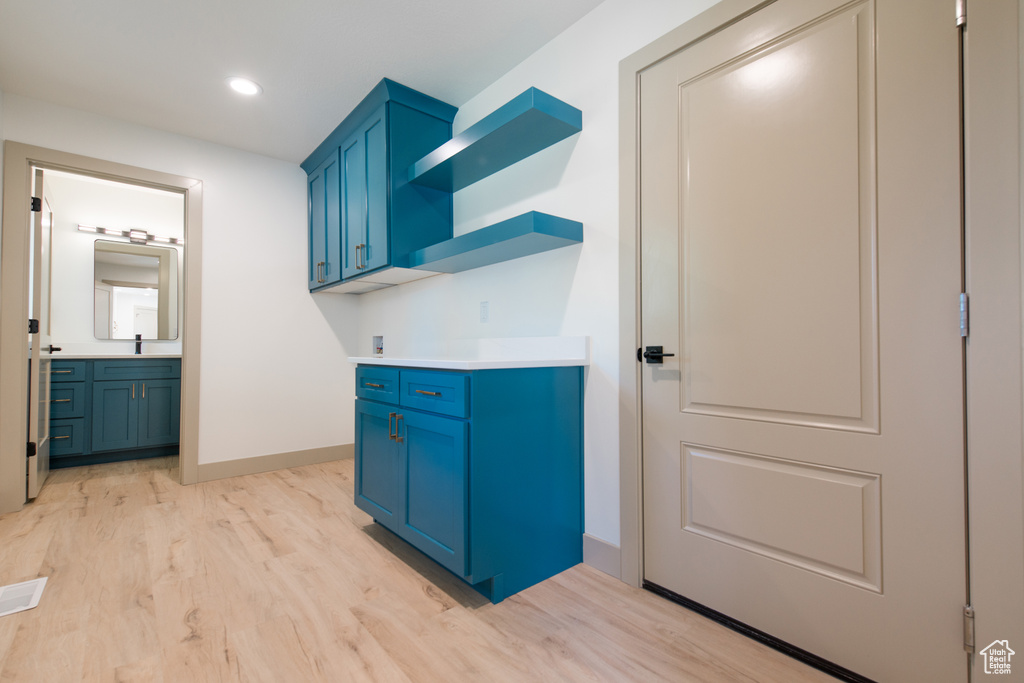 Laundry room with light wood finished floors, baseboards, recessed lighting, cabinet space, and hookup for a washing machine