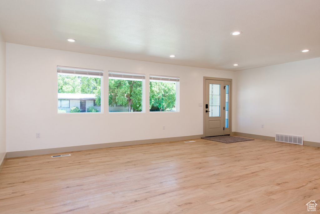 Spare room with plenty of natural light, recessed lighting, light wood-type flooring, and baseboards