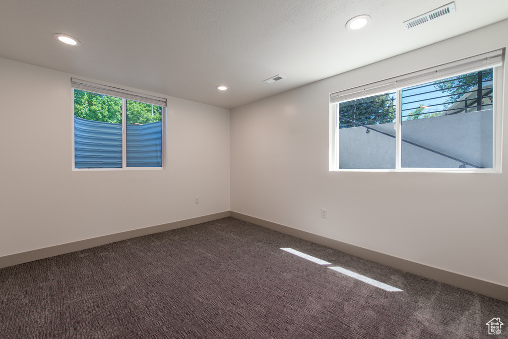 Spare room featuring recessed lighting, carpet, baseboards, and healthy amount of natural light