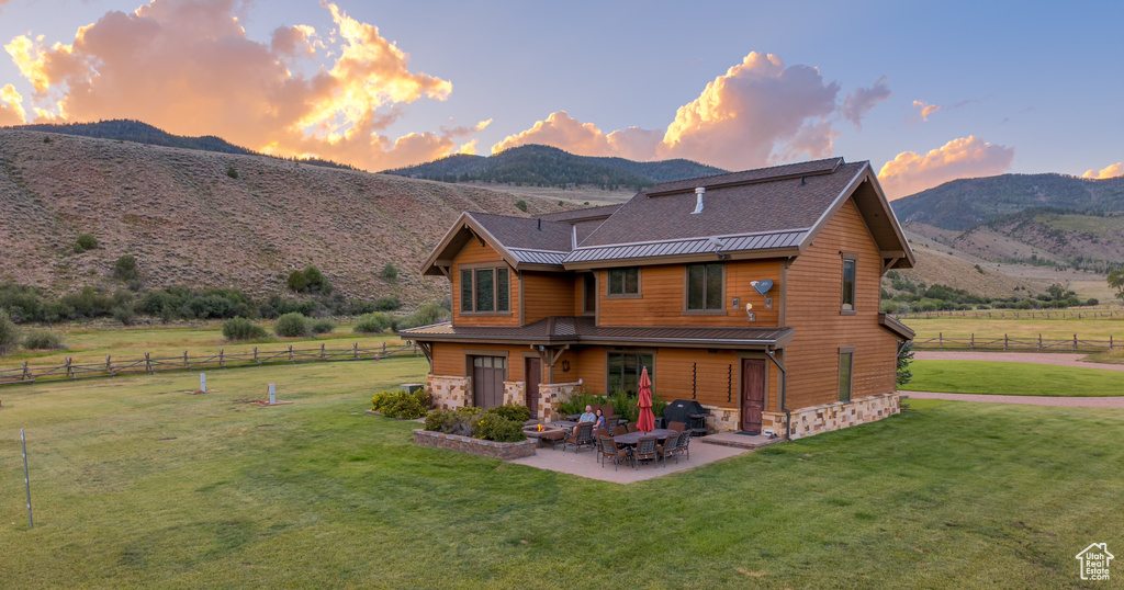 Rear view of house featuring a patio, a mountain view, a rural view, and stone siding