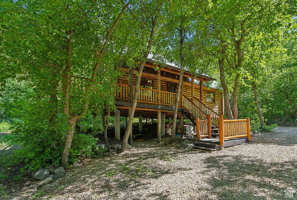Rear view of property featuring stairs and a deck