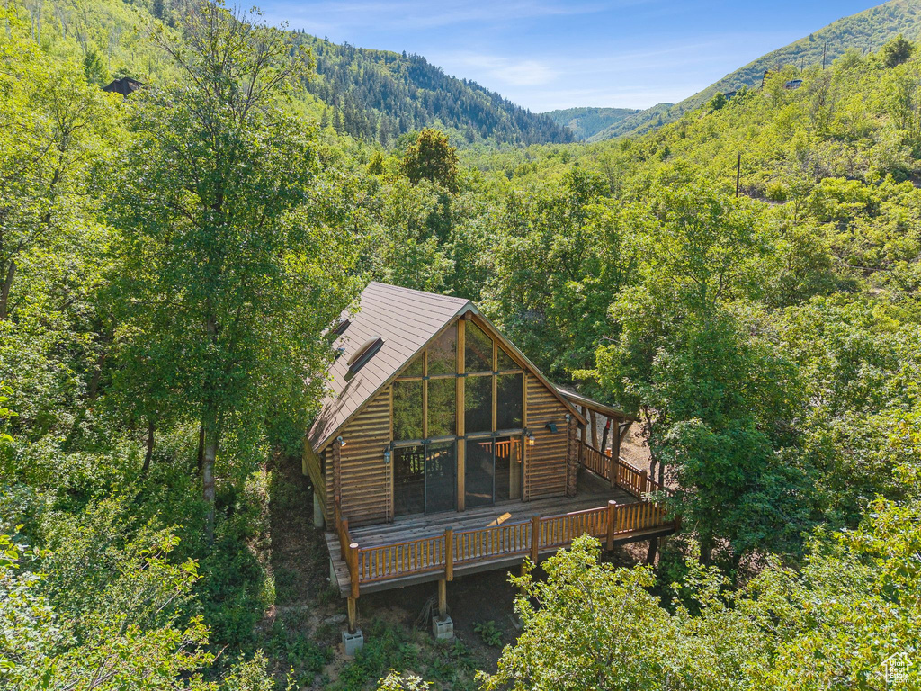 Rear view of property featuring a view of trees and a deck with mountain view