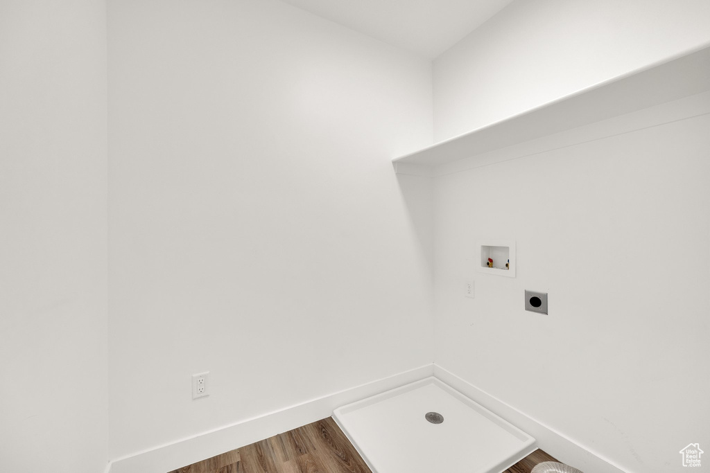 Laundry area featuring hookup for an electric dryer, hookup for a washing machine, wood finished floors, and baseboards