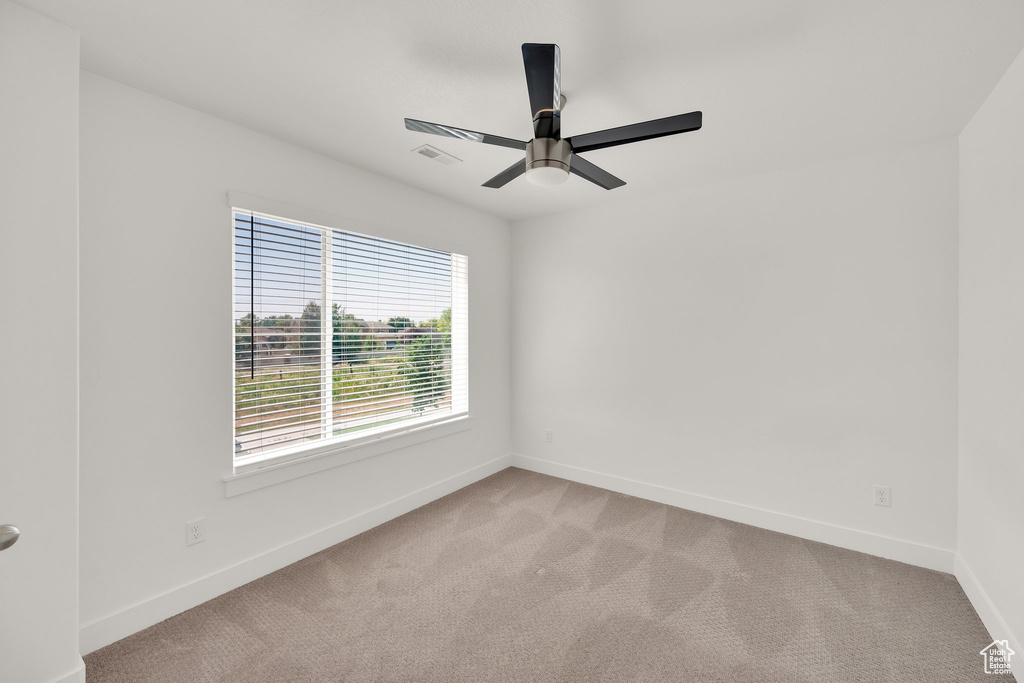Empty room with light carpet, baseboards, and ceiling fan