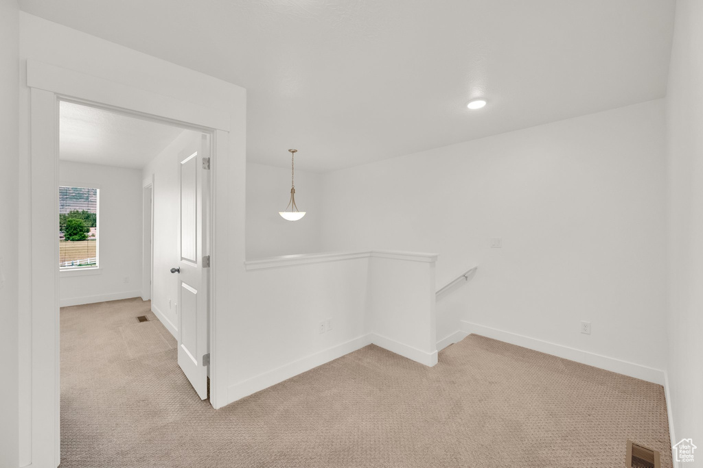 Empty room featuring light carpet and baseboards