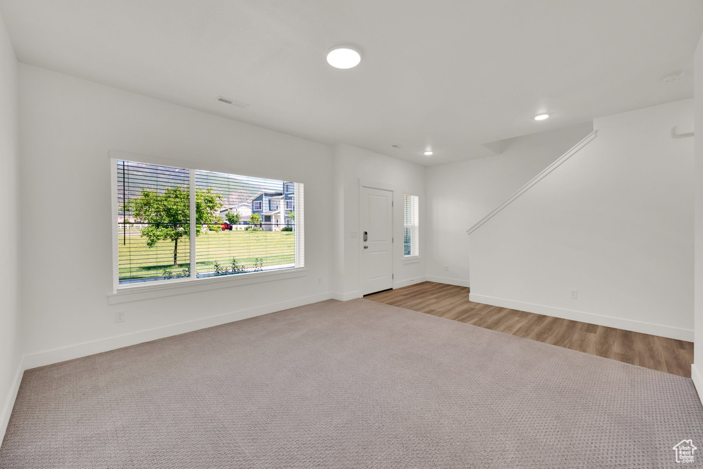 Carpeted foyer entrance with baseboards and recessed lighting