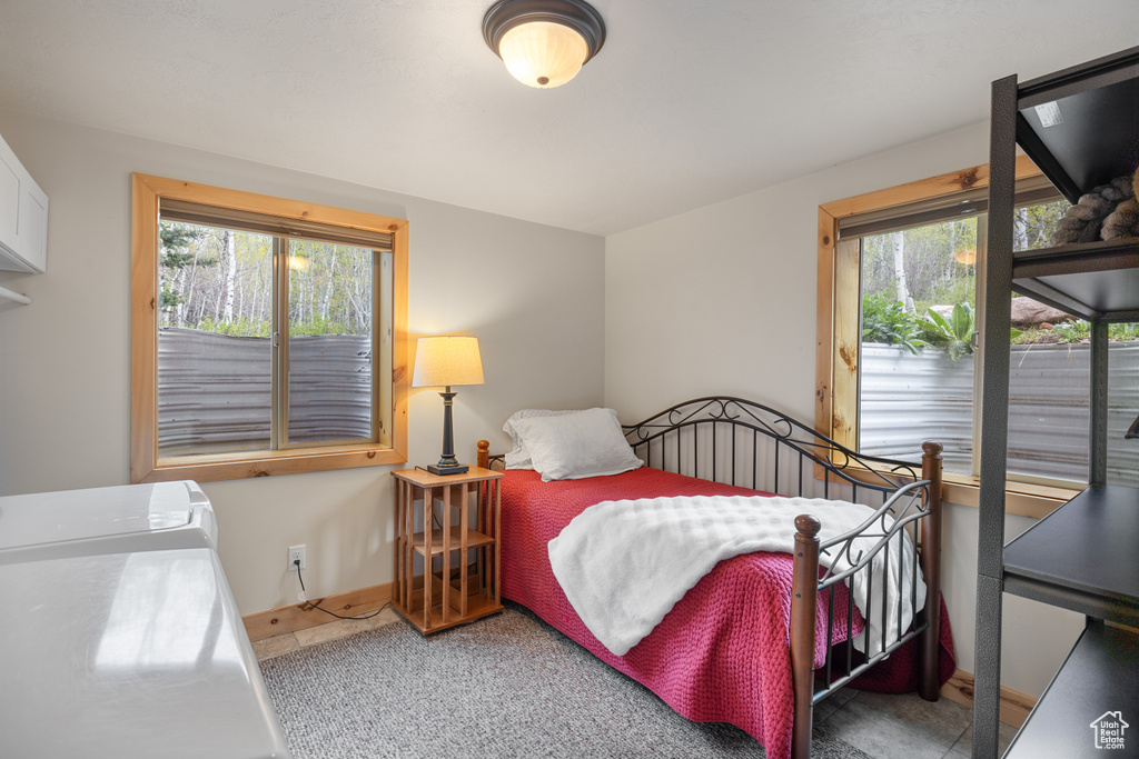 Bedroom with multiple windows, baseboards, and carpet