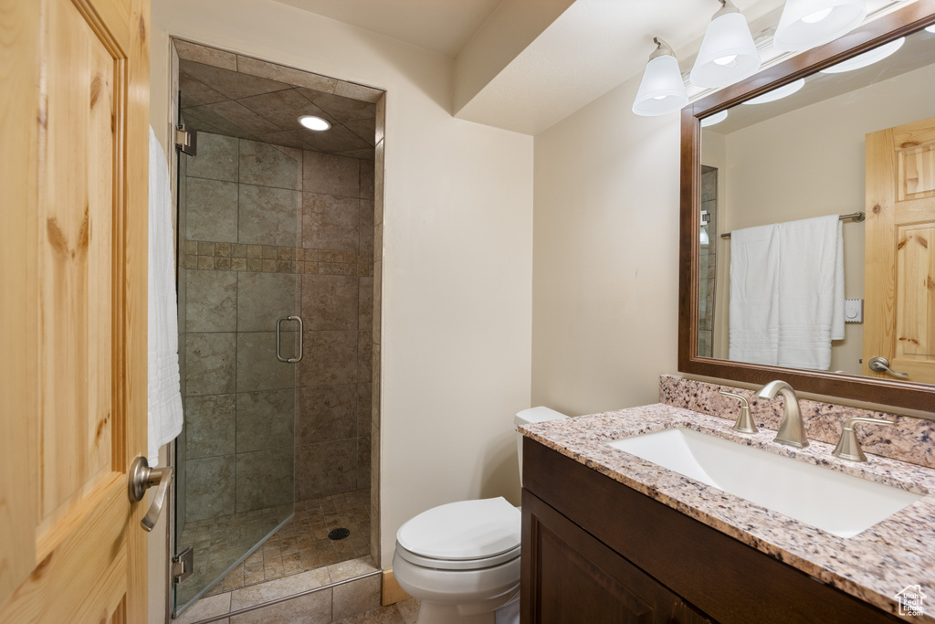 Full bathroom with vanity, toilet, and a stall shower