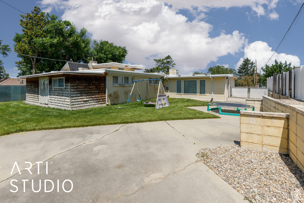 Back of house with a patio area and a playground