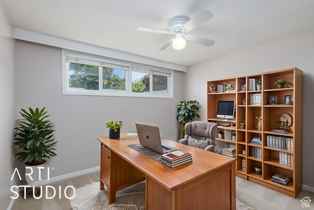 Office area with a ceiling fan, baseboards, and light colored carpet