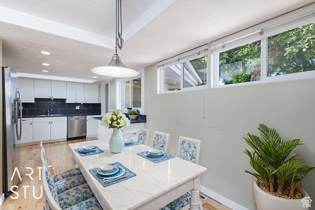 Dining area with light wood-style floors, recessed lighting, and baseboards