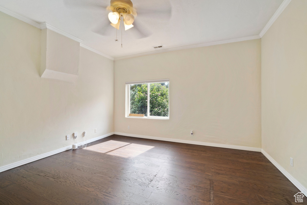 Unfurnished room with dark wood finished floors, ceiling fan, baseboards, and crown molding