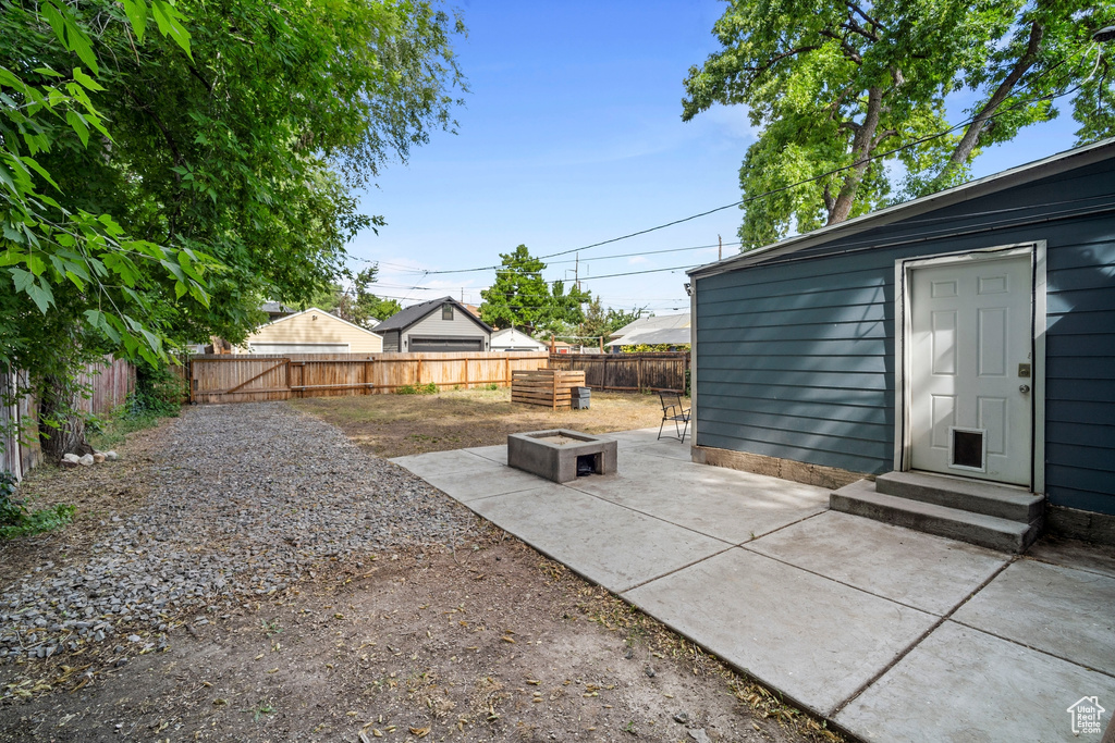 Fenced backyard with a patio, a fire pit, and entry steps