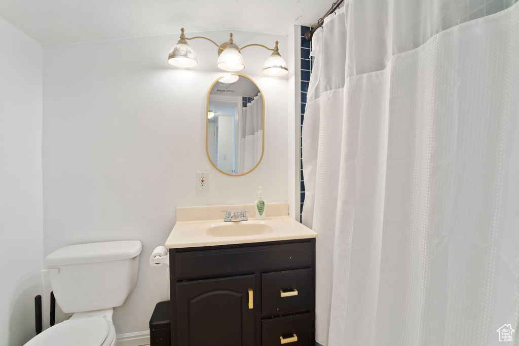 Bathroom with vanity, toilet, and baseboards