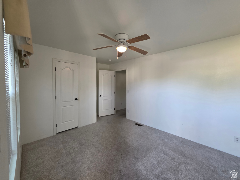 Unfurnished bedroom with carpet floors and a ceiling fan