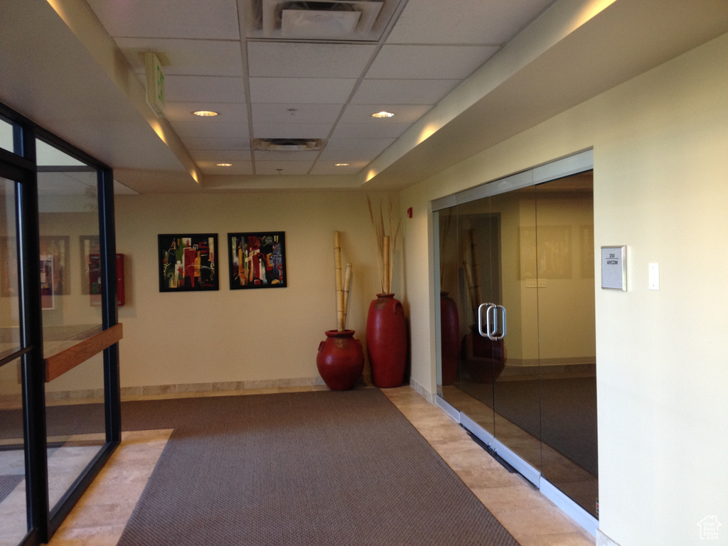 Hallway with a paneled ceiling, carpet floors, recessed lighting, and baseboards