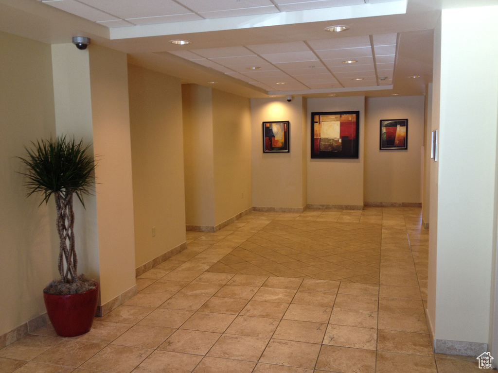 Hall featuring a drop ceiling, light tile patterned flooring, recessed lighting, and baseboards