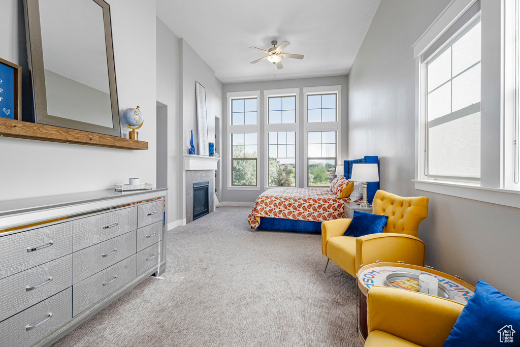 Carpeted bedroom featuring a fireplace, baseboards, and ceiling fan