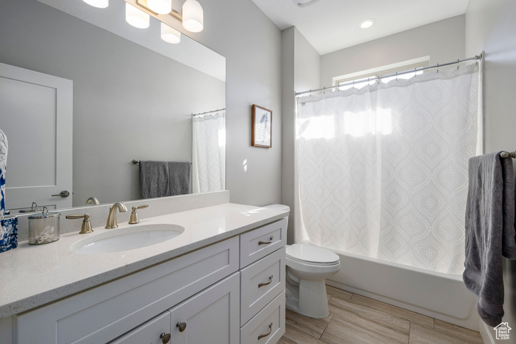 Full bath featuring vanity, toilet, and shower / tub combo