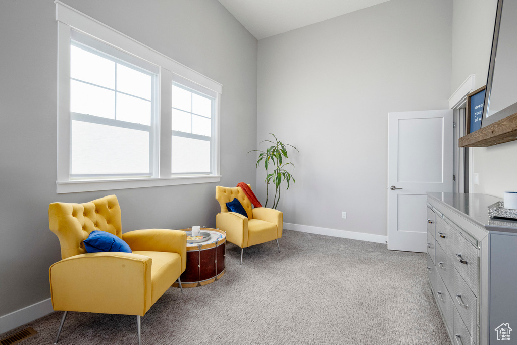 Living area featuring carpet flooring and baseboards