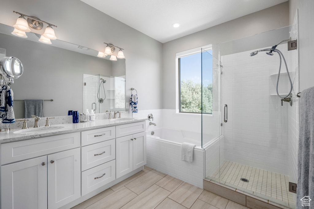 Full bath with a shower stall, a bath, and double vanity