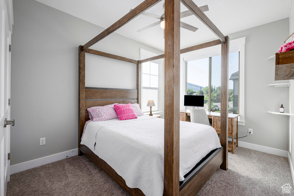 Carpeted bedroom with baseboards and a ceiling fan