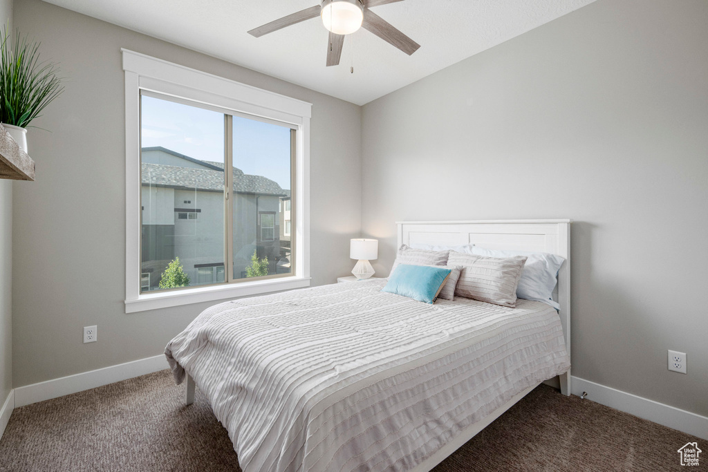 Carpeted bedroom featuring baseboards and ceiling fan