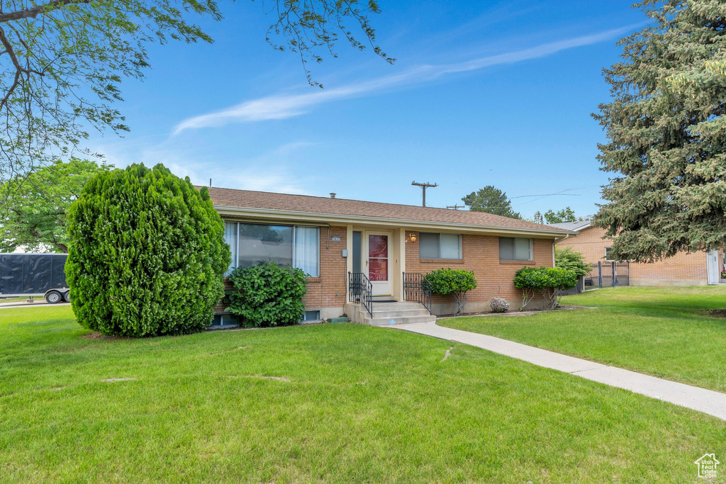 Single story home featuring a front yard and brick siding