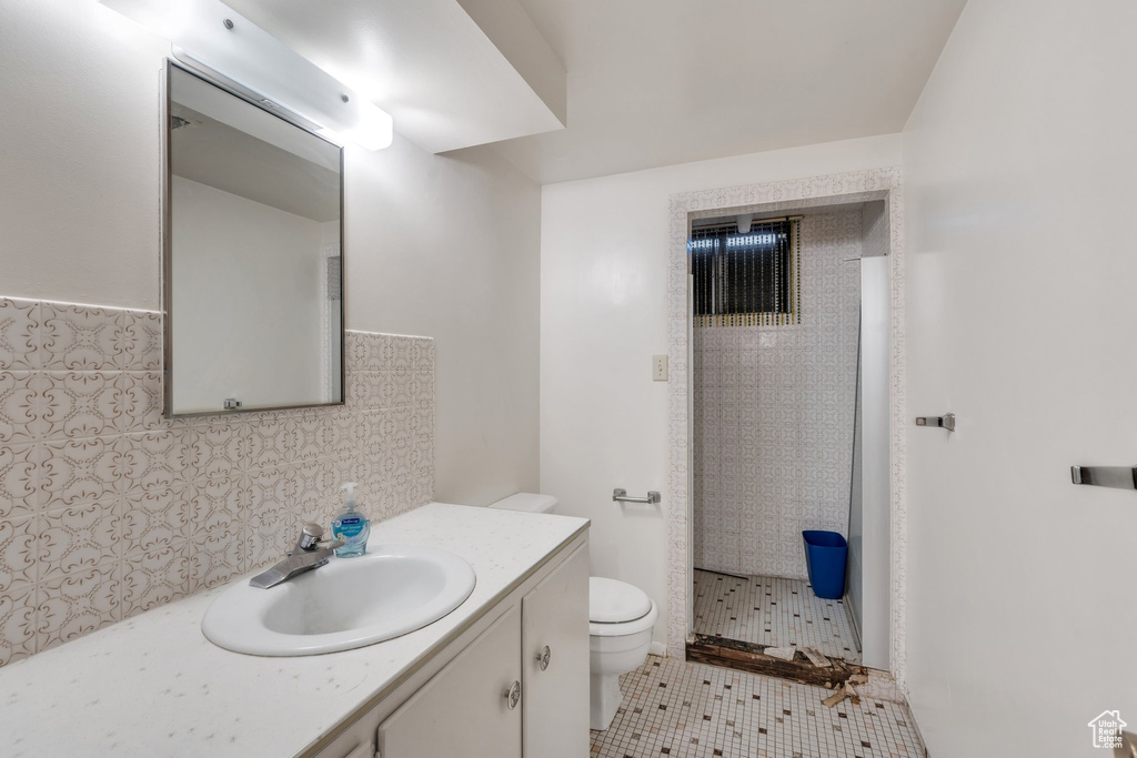 Full bathroom with vanity, a shower stall, tasteful backsplash, and tile patterned flooring