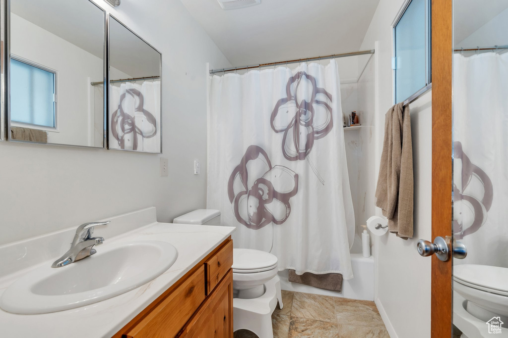 Bathroom featuring vanity and shower / tub combo with curtain