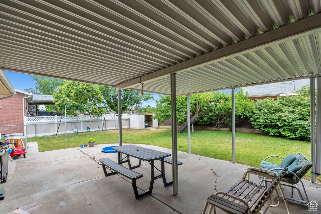 Fenced backyard featuring a storage shed, a patio area, and outdoor dining space