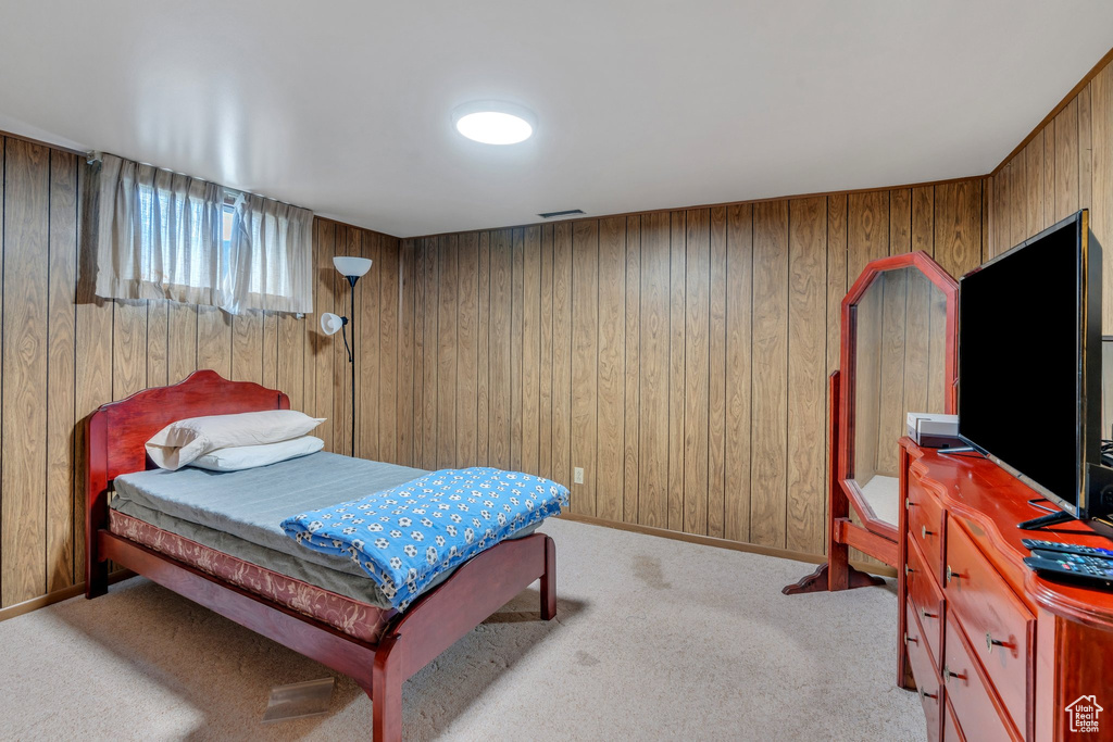 Bedroom featuring wooden walls and carpet