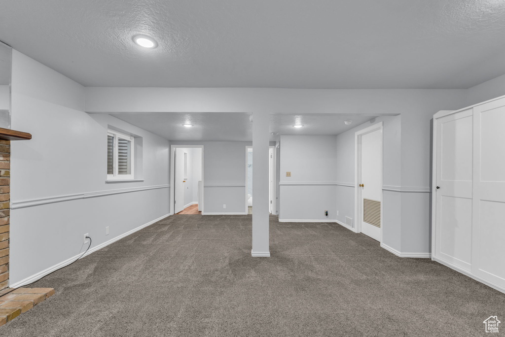 Finished below grade area featuring carpet floors, baseboards, a textured ceiling, and recessed lighting