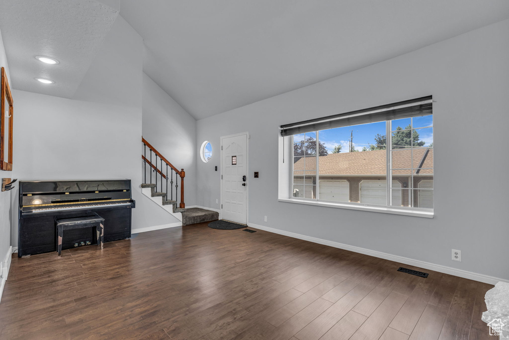 Foyer entrance featuring stairway, vaulted ceiling, wood finished floors, and baseboards