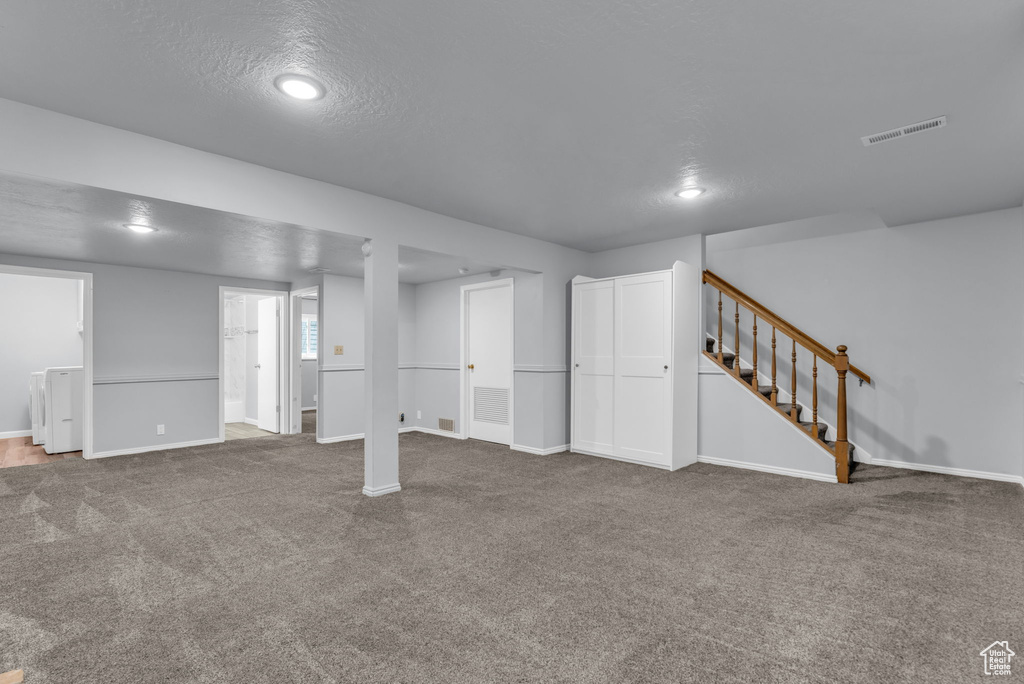 Finished below grade area featuring carpet floors, baseboards, stairway, and recessed lighting