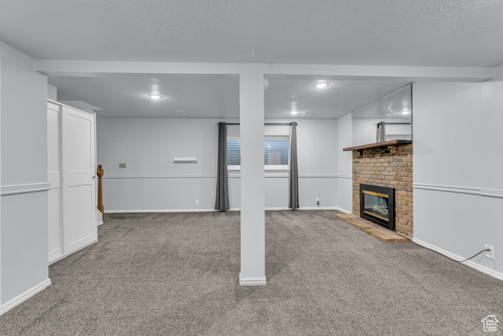 Basement featuring carpet flooring, a fireplace, baseboards, and recessed lighting