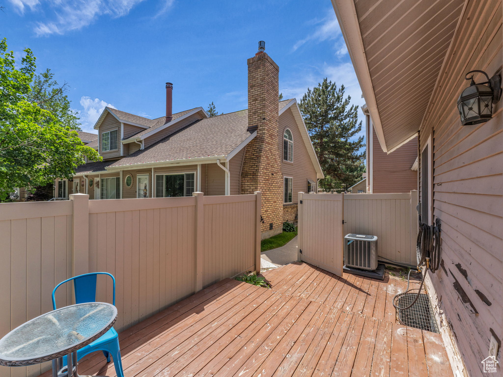 Wooden terrace featuring cooling unit