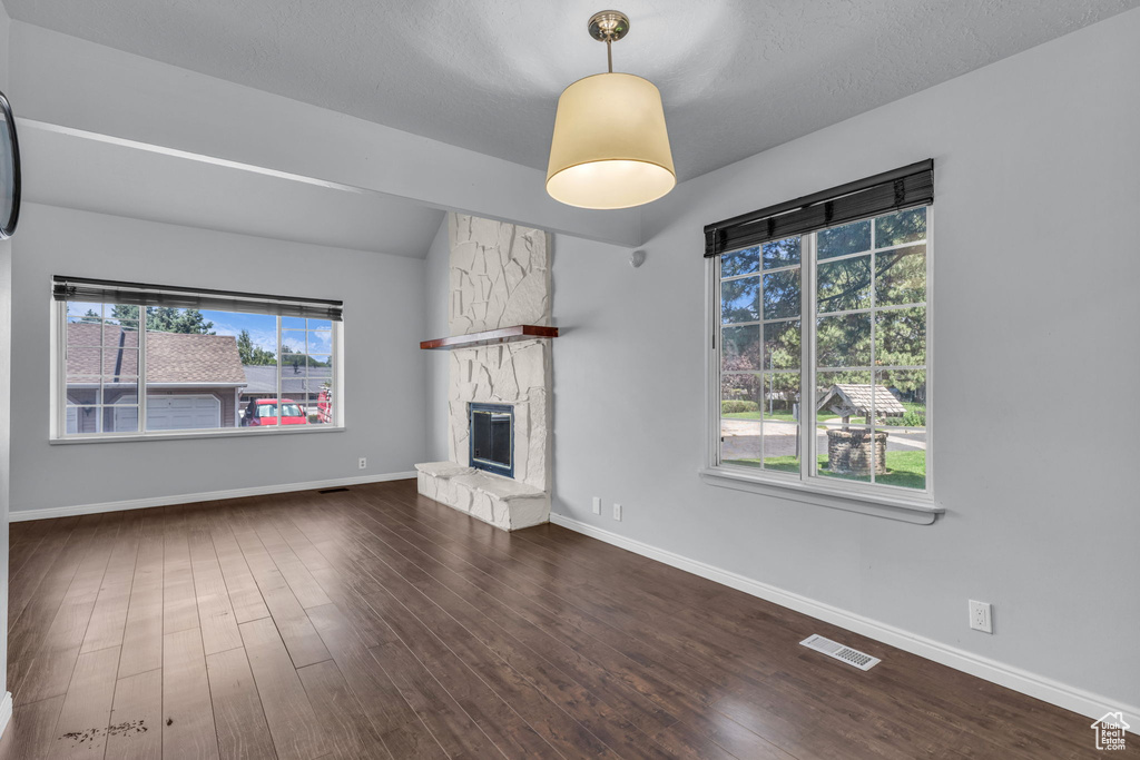 Unfurnished living room with a fireplace, wood finished floors, and baseboards