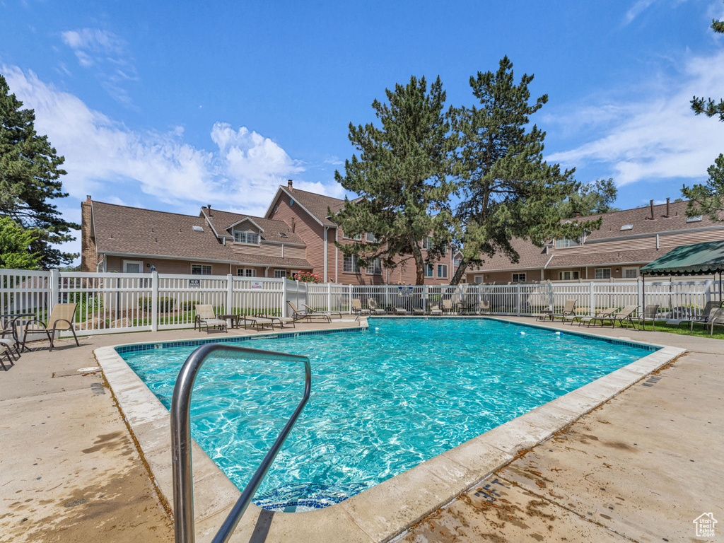 Community pool with a patio area and a residential view