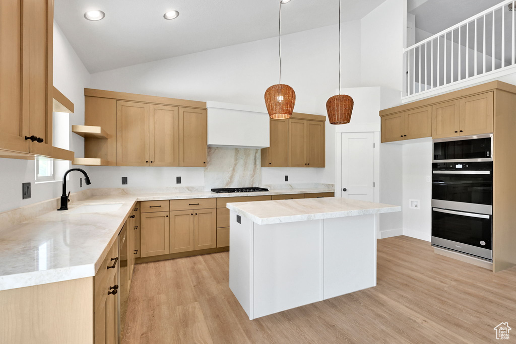 Kitchen featuring a sink, gas stovetop, high vaulted ceiling, double wall oven, and open shelves