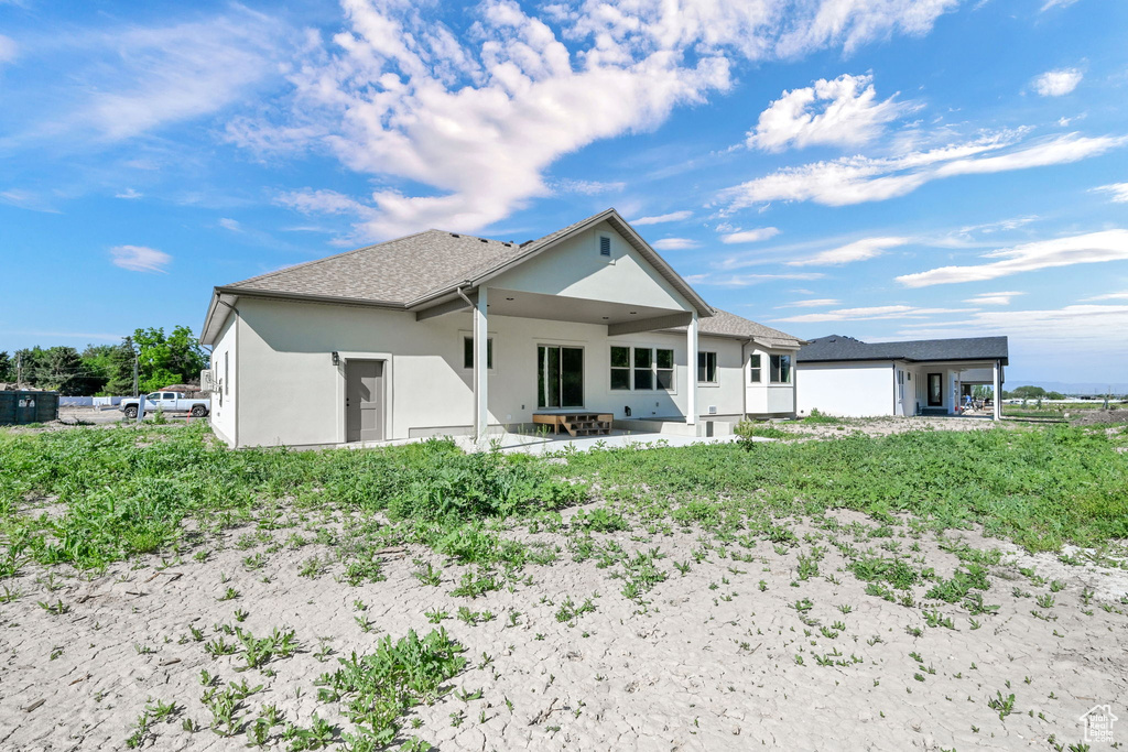 Back of property featuring stucco siding and a patio