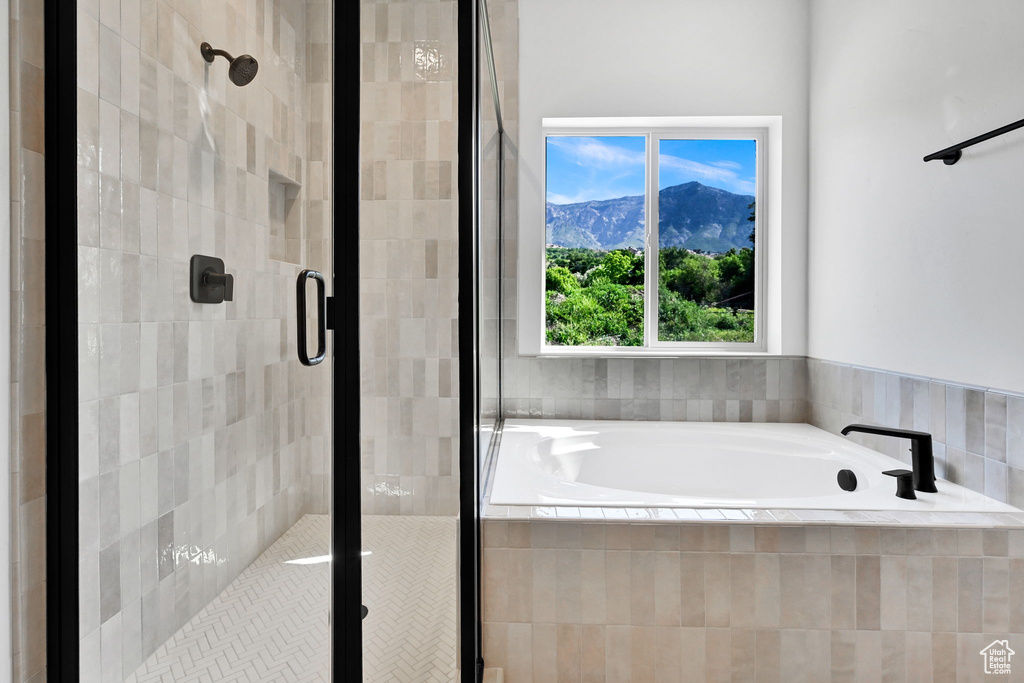 Bathroom with a bath, a stall shower, and a mountain view