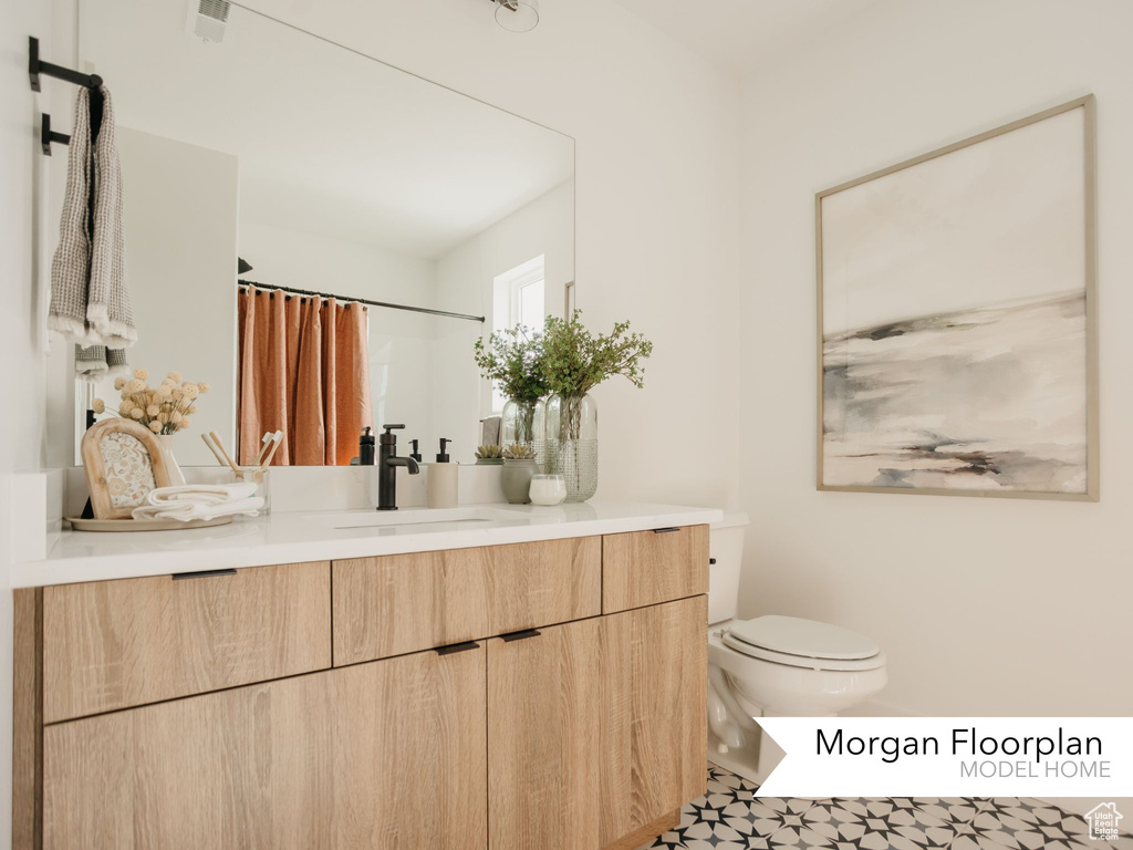 Bathroom with vanity, toilet, and curtained shower