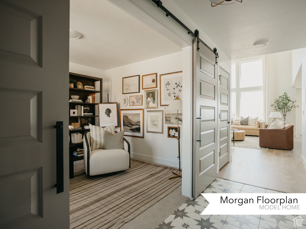 Living area with a barn door and baseboards