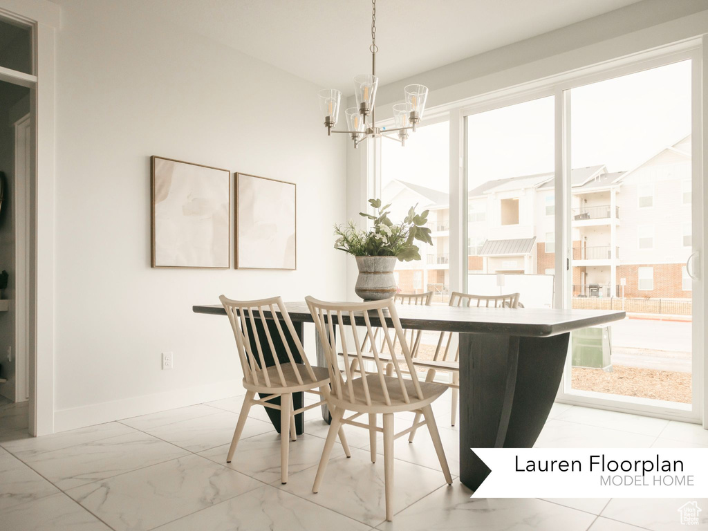 Dining space featuring plenty of natural light, a chandelier, marble look tiles, and baseboards